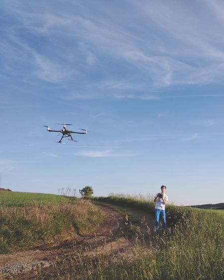 Man with drone on grassy field
