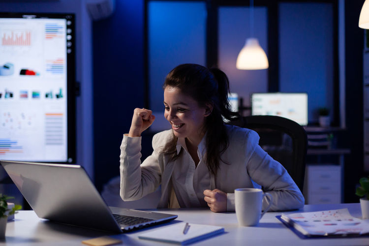 Woman using phone while sitting on table