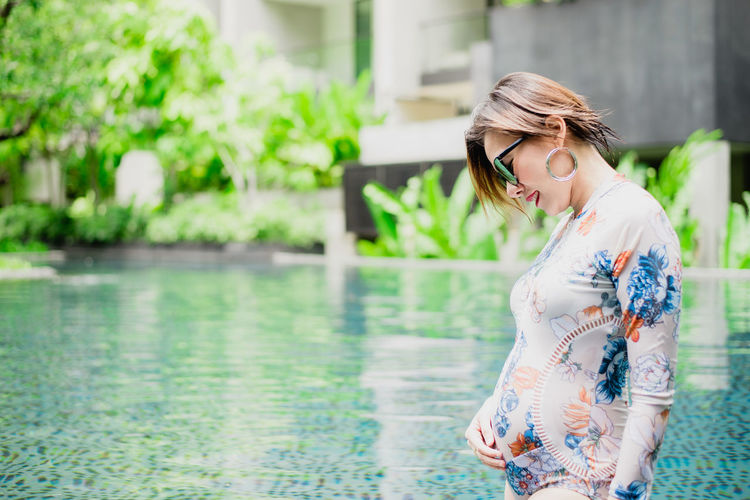 Young woman standing in swimming pool