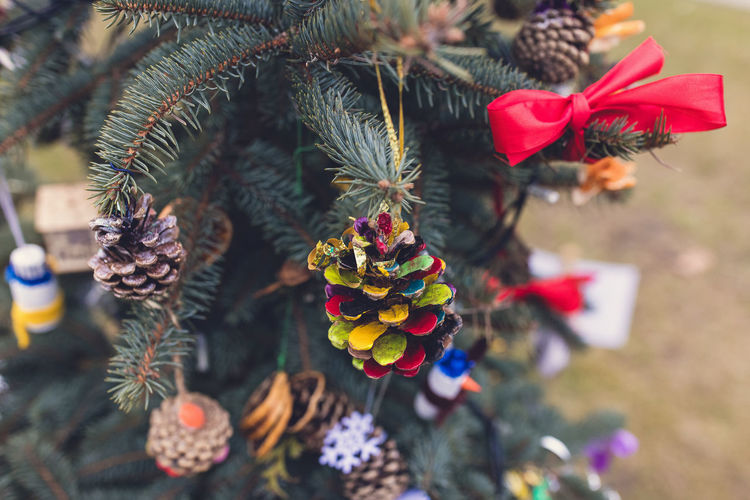 Painted pine cone on christmas tree. diy decoration ideas for children. environmental concept