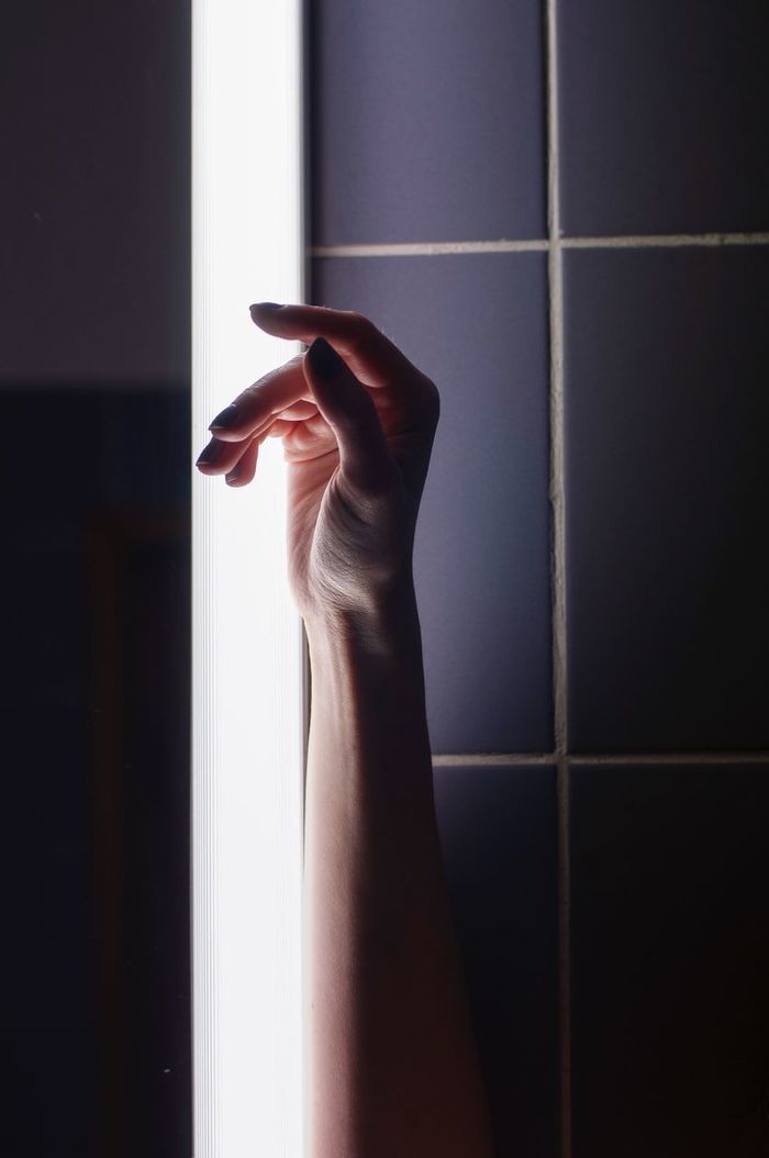 Cropped hand by wall
