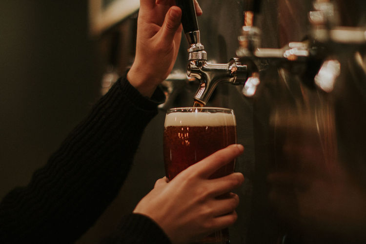 Female hands pouring beer