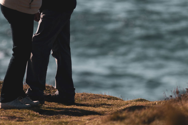 Low section of couple standing on beach