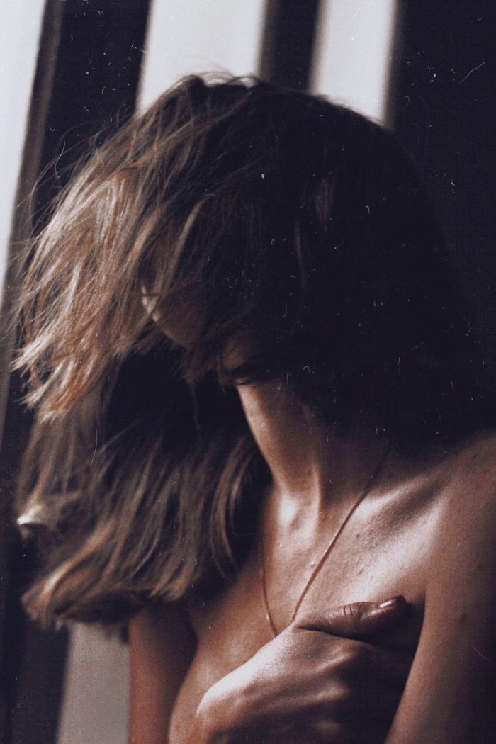 Close-up of shirtless young woman with messy hair at home
