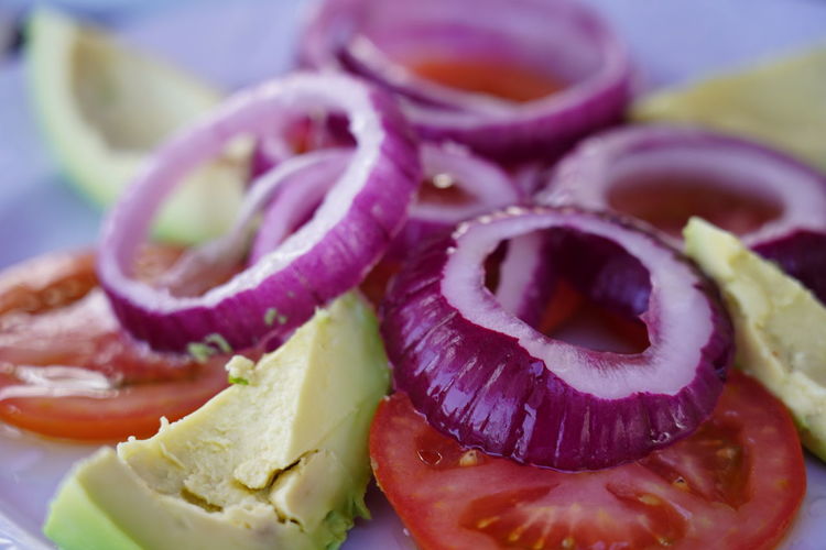Raw vegan salad of fresh onion rings, tomatoe and avocado slices, tenerife, canary islands