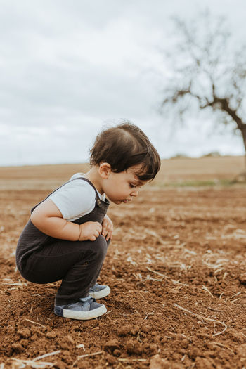 Portrait of child looking at ants in the fields