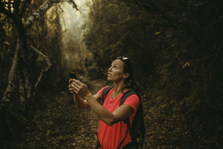 Young woman using mobile phone while standing on land