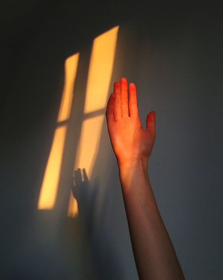 Cropped hand of man against wall