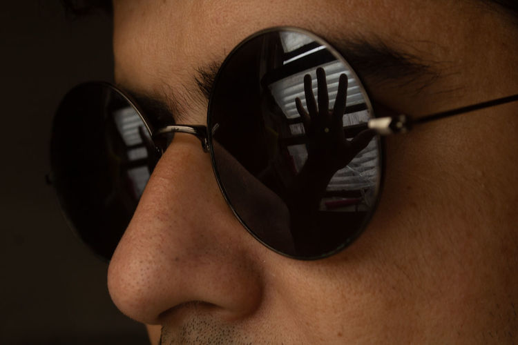 Close-up of human hand on sunglasses