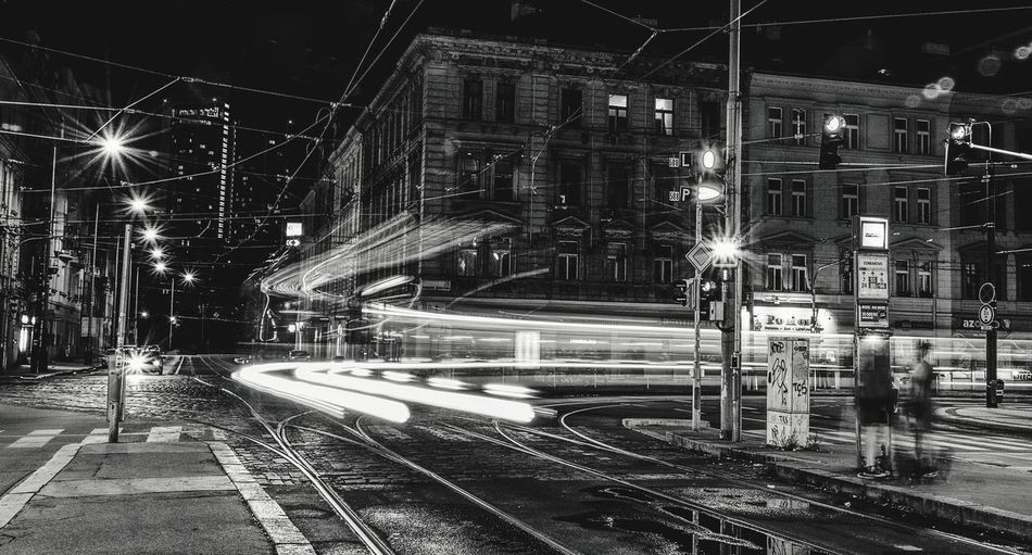 Light trails on railroad tracks in city at night
