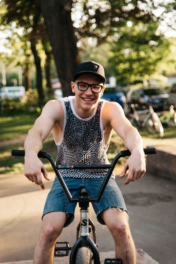 Full length portrait of smiling man riding bicycle