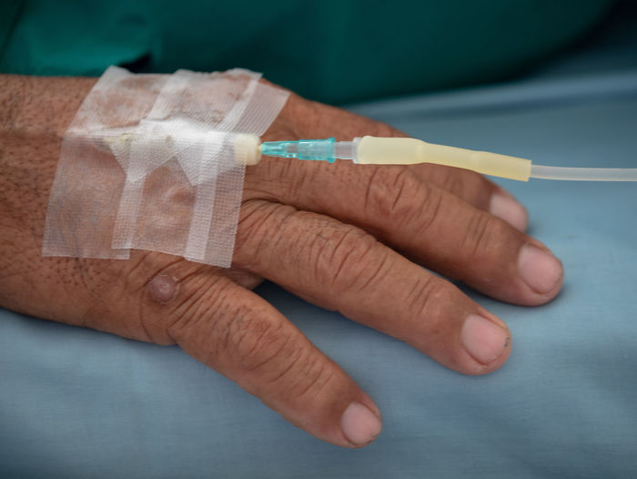 Close-up of man with iv drip at hospital