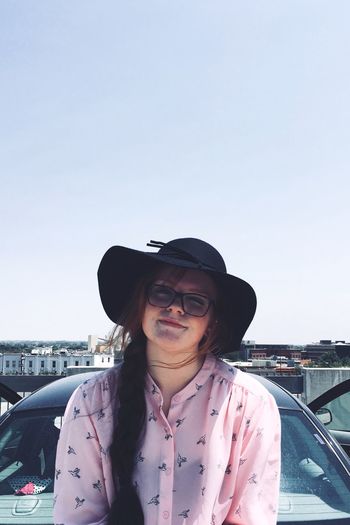 Portrait of smiling woman wearing hat while standing against sky