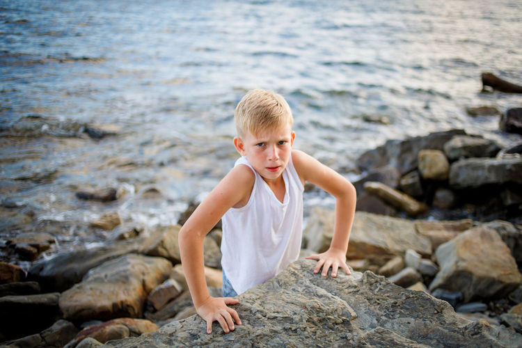 Boy on rock at sea shore