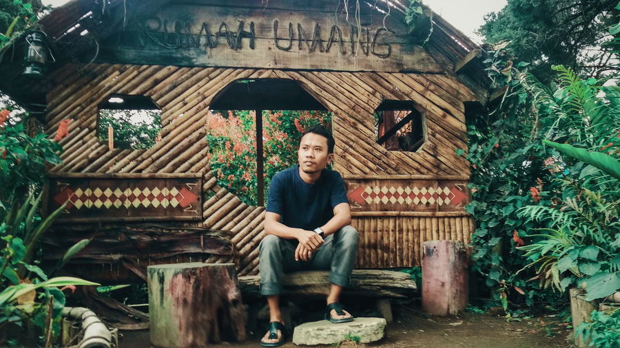 Young man sitting outside hut