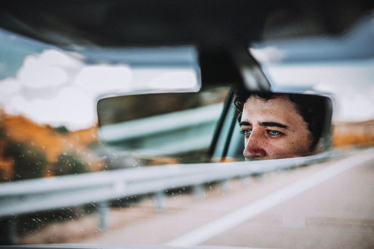 Portrait of man seen through car window