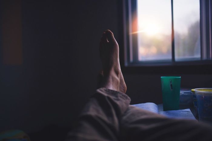 Low section of person resting at home during sunset