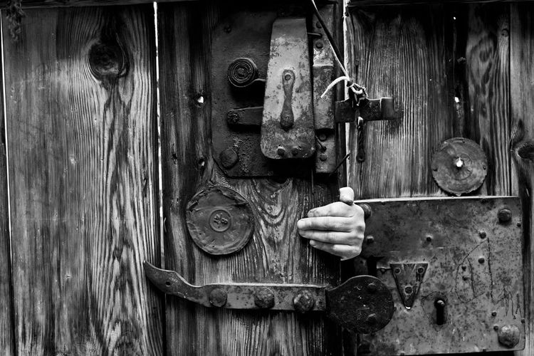 Cropped hand opening wooden door