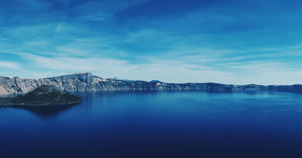 Scenic view of calm crater lake against blue sky
