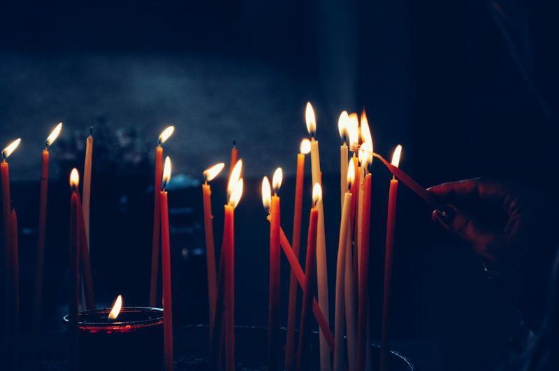 Close-up of burning candles in the darkness