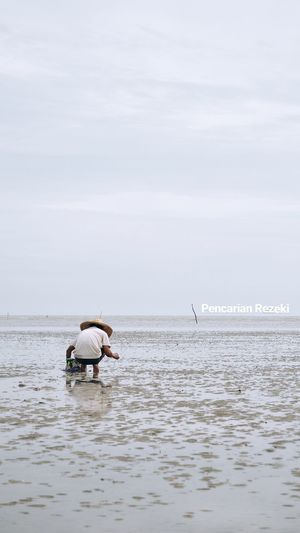 Man in sea against sky