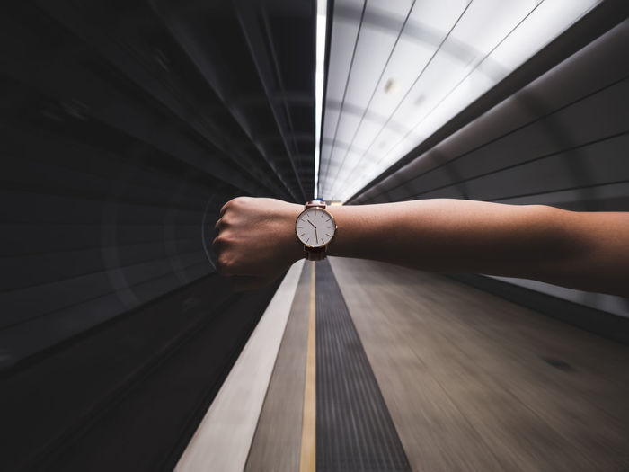 Cropped image of woman hand showing wristwatch at subway station