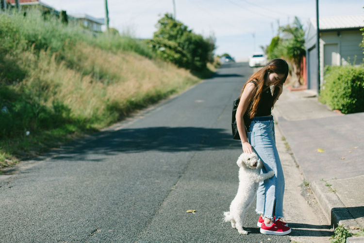 Woman playing dog on road