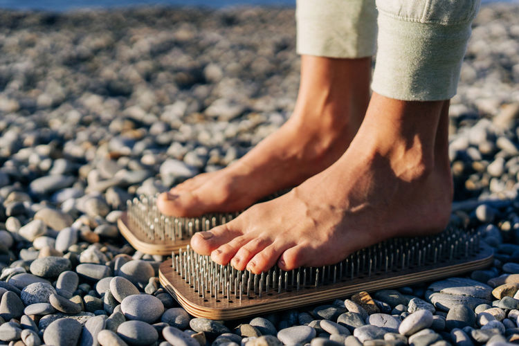 Close up of female feet on boards with nails.