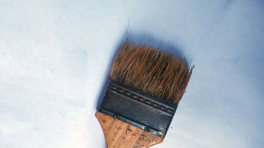 High angle view of paintbrushes on floor against wall