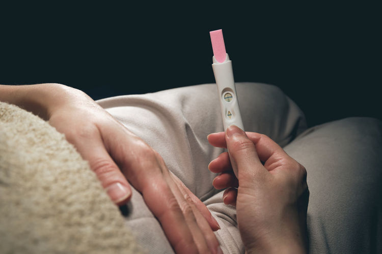 A woman sees a positive pregnancy test result