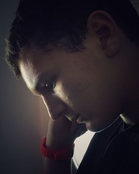 Side view of thoughtful young man with hand on chin