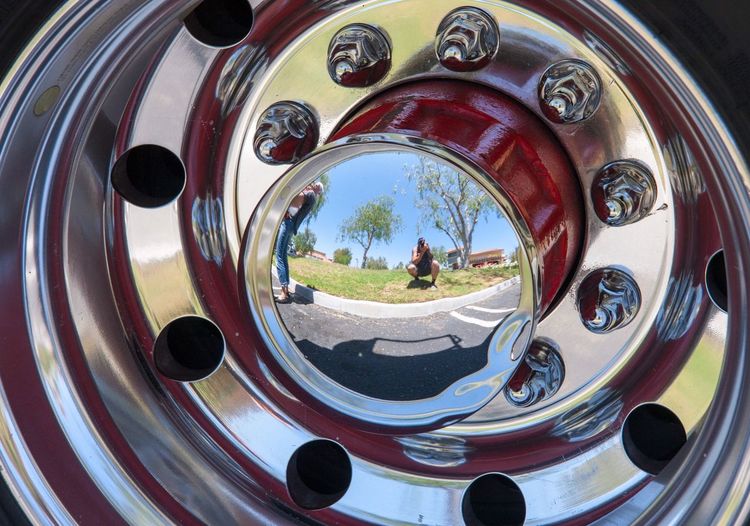 Close-up reflection in the rim of a fire engine wheel 