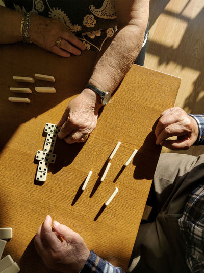 Overhead view of old couple playing dominoes 