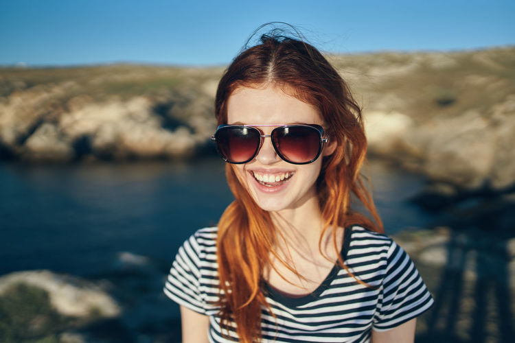 Portrait of smiling young woman wearing sunglasses