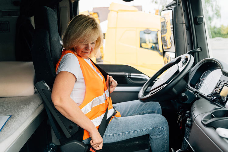 Woman wearing seat belt sitting in truck