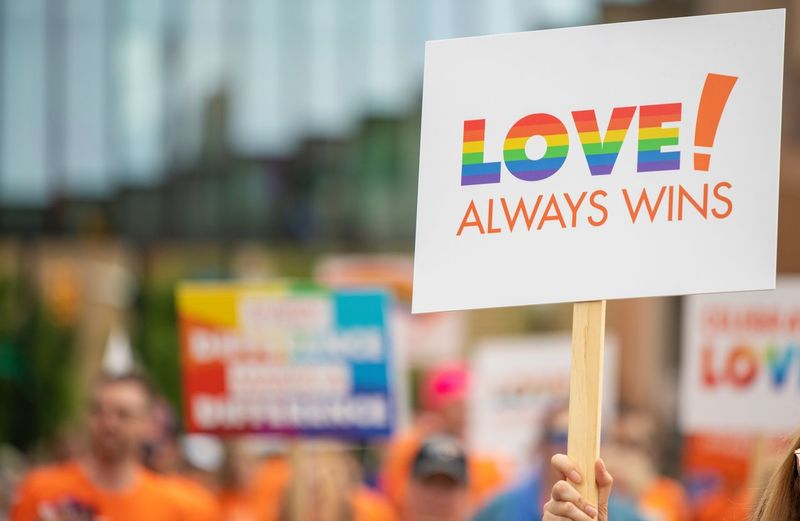 Cropped hand of woman holding placard with text