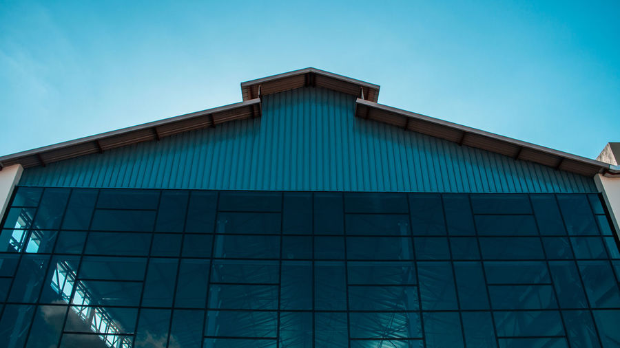 Low angle view of modern building against clear blue sky