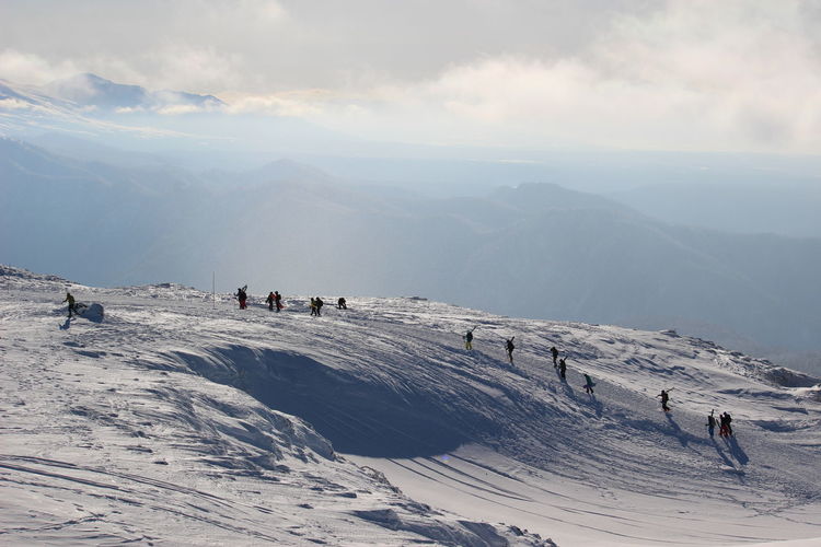 People skiing on snowcapped mountain against sky