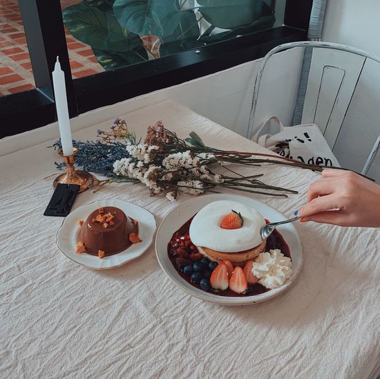 Cropped hand of woman having food at table