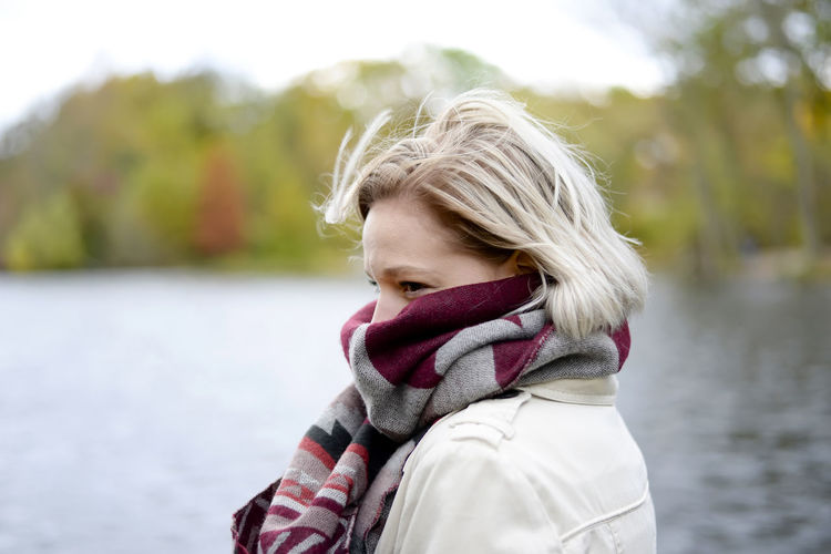 Close-up of woman wearing scarf against lake