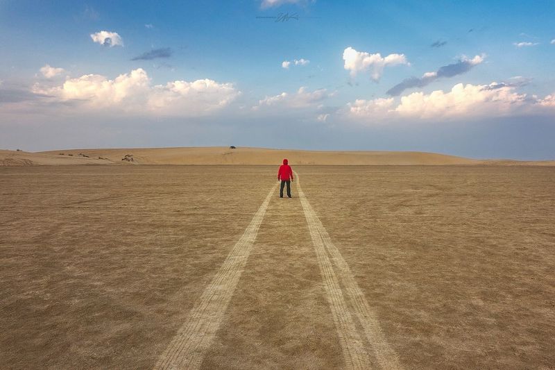 Man standing on sand against sky