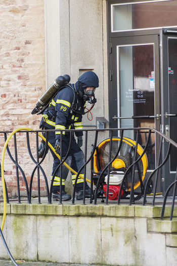 Firefighter with hose in front of building