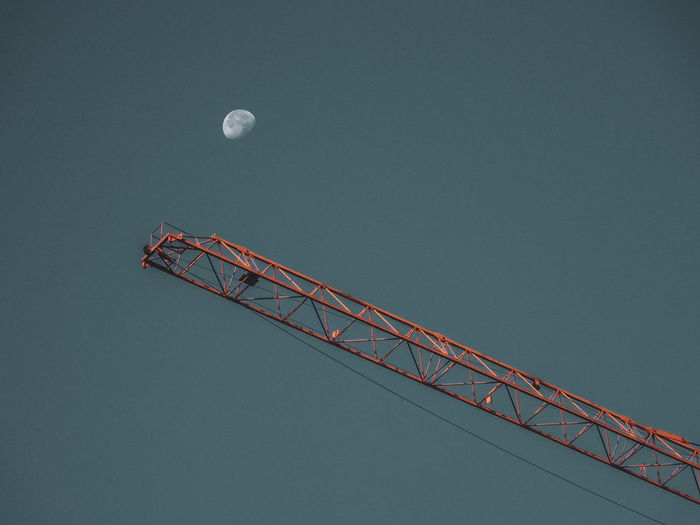 Low angle view of crane against sky at dusk