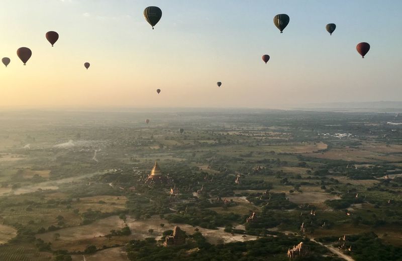 Aerial view of hot air balloons flying in sky