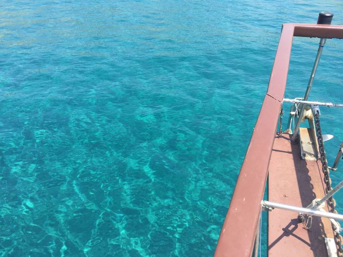 High angle view of pulley on metal structure over turquoise sea