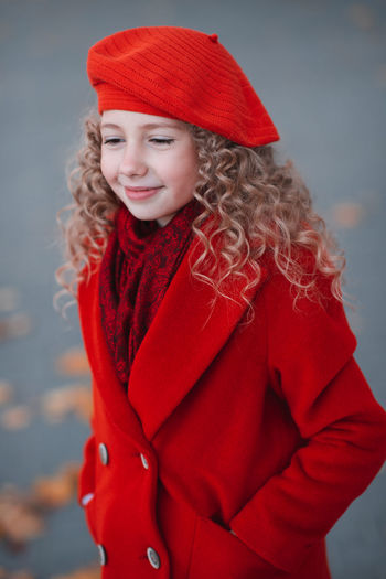 Stylish smiling happy kid girl 5-6 year old with blonde curly hair wear red jacket and beret hat