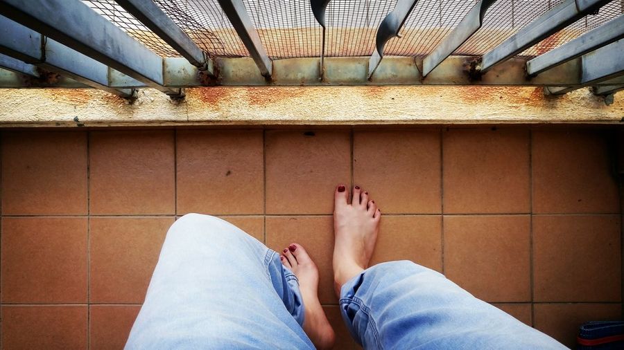 Low section of feet relaxing on a balcony