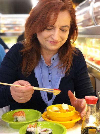 Smiling mature woman having food in restaurant