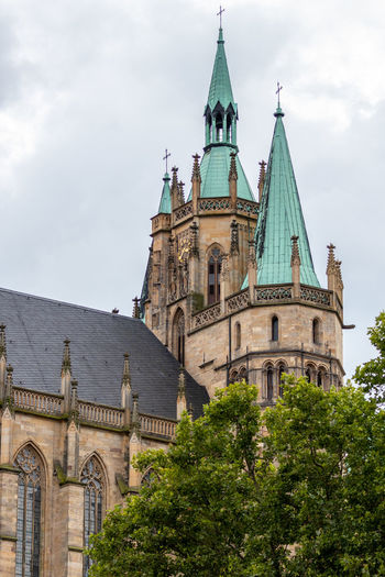 View of the towers of the cathedral in erfurt with green tree in the foreground