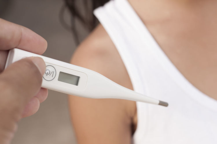Cropped image of hand holding pregnancy test by woman